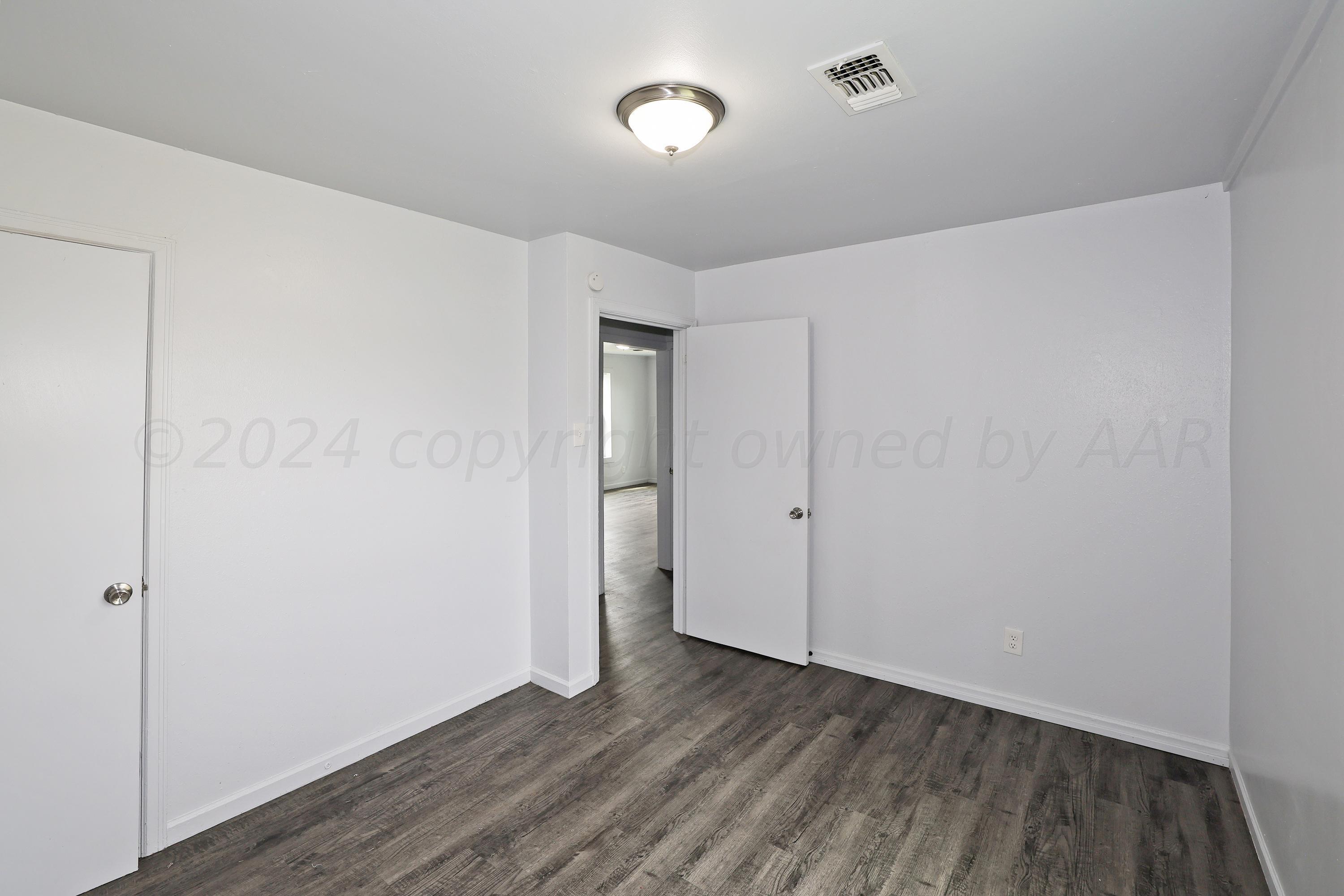 3703 South Monroe Street Amarillo, TX 79110 - Photo 12 of 13 a view of an empty room with wooden floor