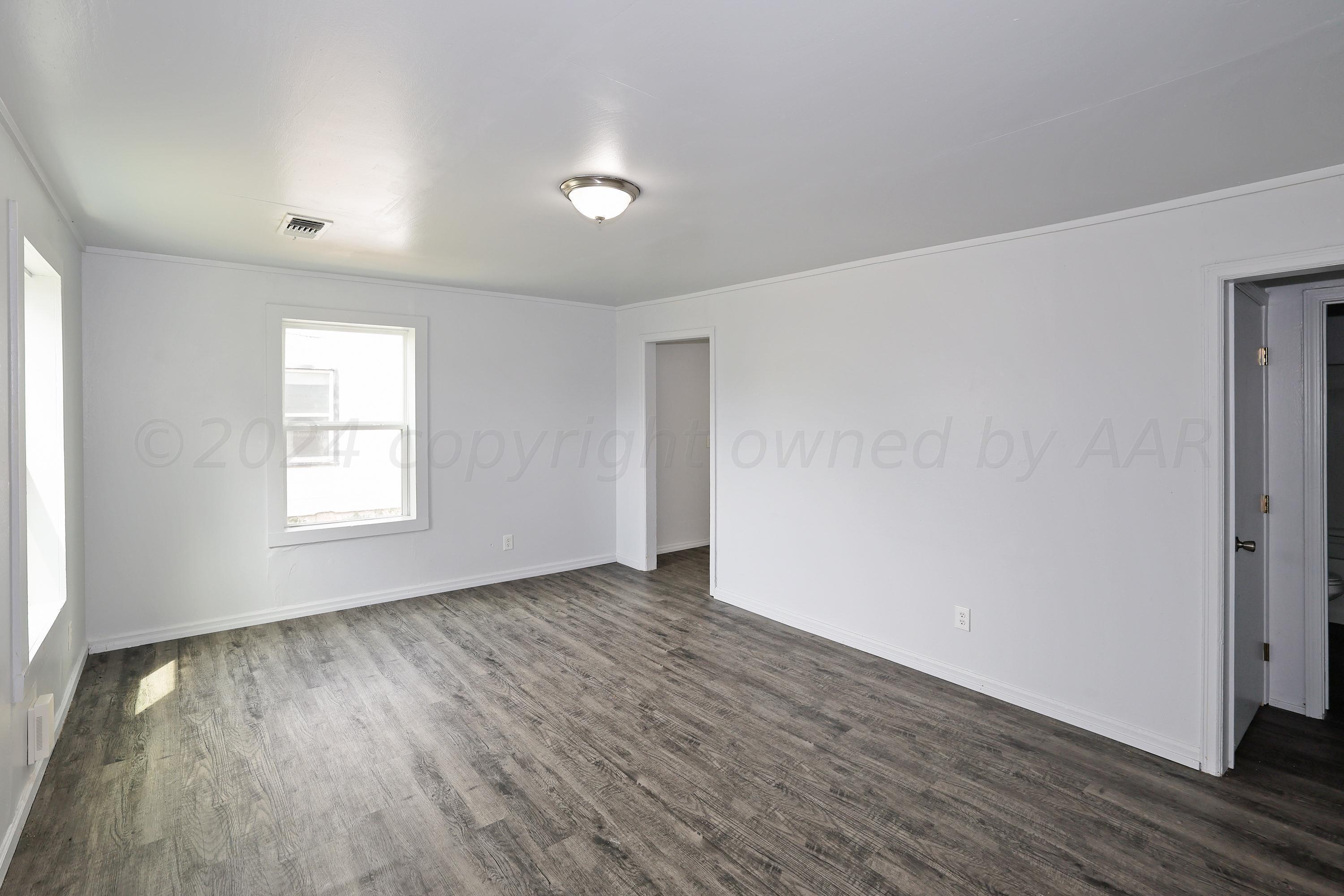 3703 South Monroe Street Amarillo, TX 79110 - Photo 2 of 13 a view of an empty room with wooden floor and a window