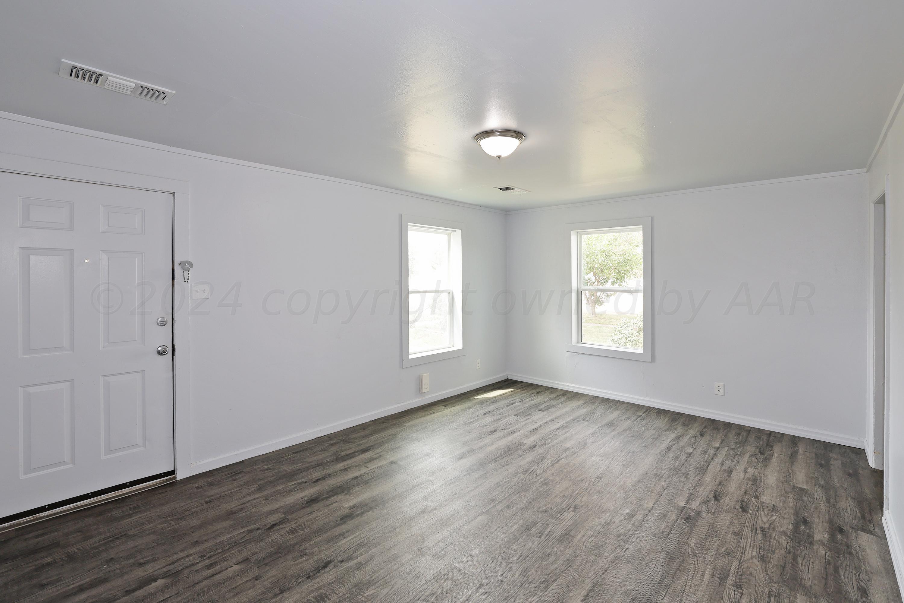 3703 South Monroe Street Amarillo, TX 79110 - Photo 4 of 13 an empty room with wooden floor and windows