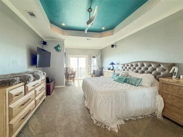 a spacious bedroom with a bed and a chandelier