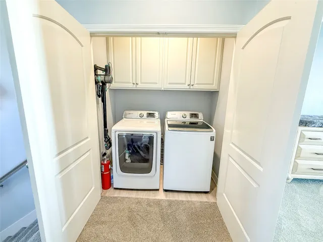 a utility room with wooden floor washer and dryer