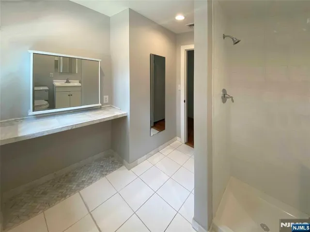 a bathroom with a mirror and a shower