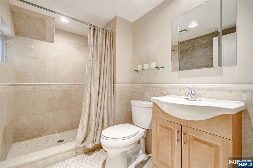 41 Demarest Avenue Demarest, NJ 07627 - Photo 20 of 28 a bathroom with a sink a toilet and shower