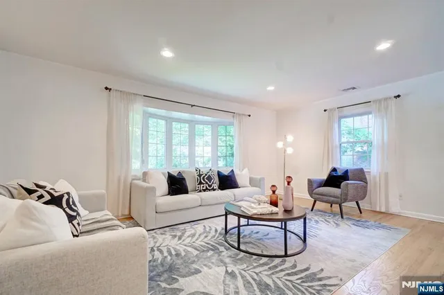 a living room with furniture wooden floor and a large window