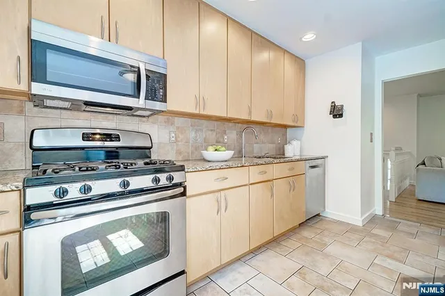 a kitchen with granite countertop cabinets stainless steel appliances and wooden cabinets