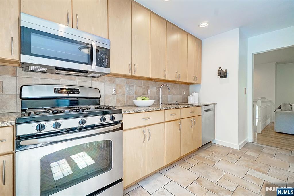 41 Demarest Avenue Demarest, NJ 07627 - Photo 9 of 28 a kitchen with granite countertop cabinets stainless steel appliances and wooden cabinets