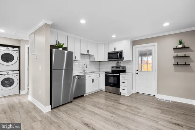 a kitchen with a refrigerator a stove top oven a sink and dishwasher with wooden floor