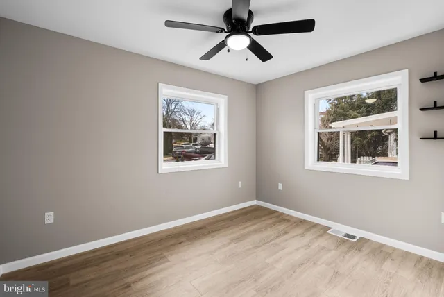 a view of empty room with window and ceiling fan