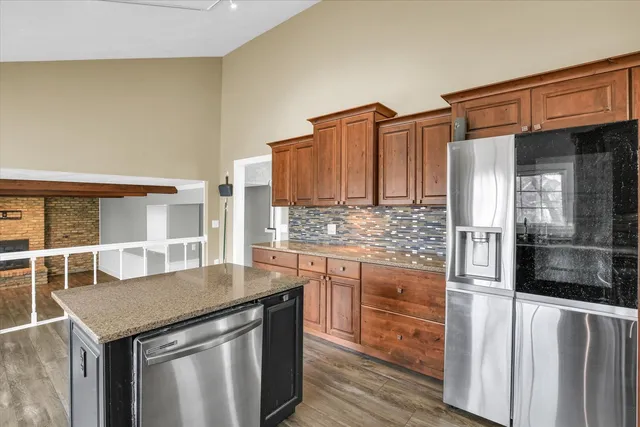 a kitchen with stainless steel appliances granite countertop a sink and a refrigerator