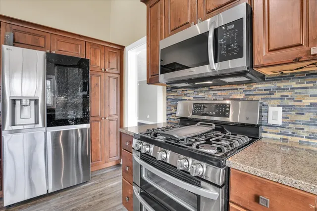 a kitchen with stainless steel appliances granite countertop a stove and a microwave