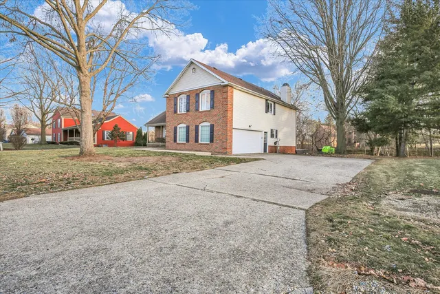 a view of a white house with a large trees next to a road