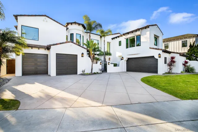 a view of a white house with a small yard and a large tree