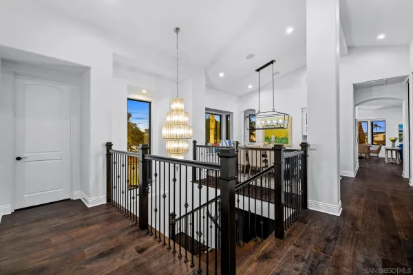 a dining room with furniture a chandelier and wooden floor