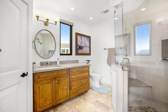 a spacious bathroom with a granite countertop sink a large mirror and a bathtub