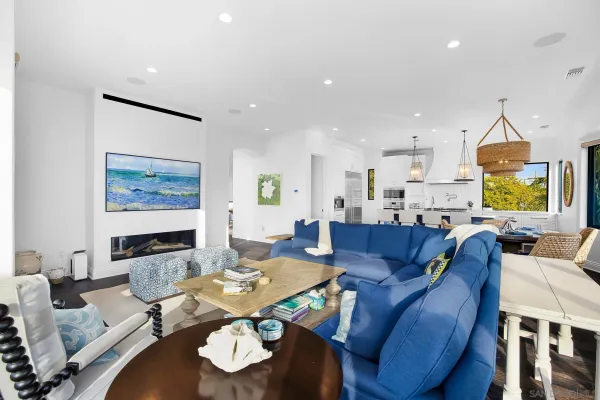 a living room with furniture hard wood floor and a floor to ceiling window