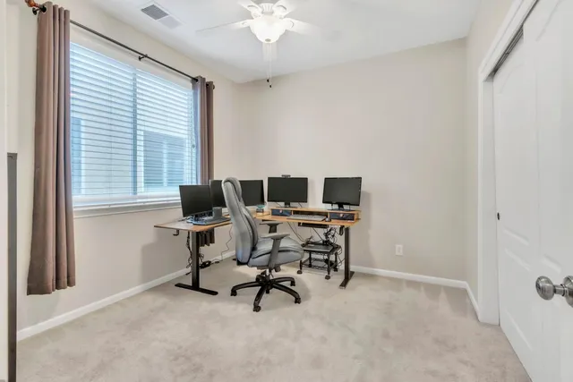 a view of a workspace with furniture and a window