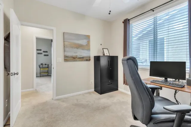 a view of a workspace with furniture and a window