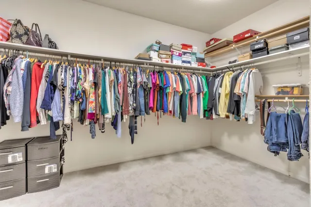a view of walk in closet with clothes