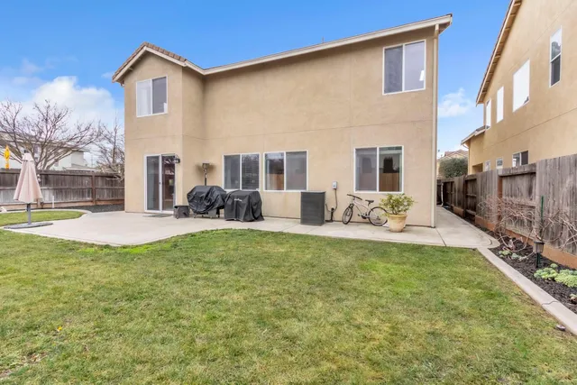 a view of a house with a yard patio and fire pit