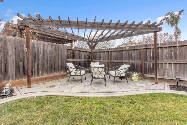 a view of a patio with table and chairs with wooden fence