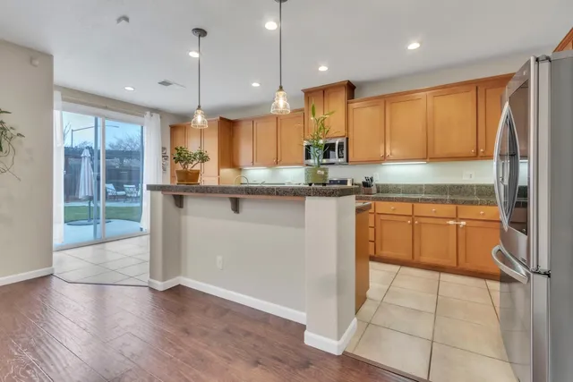 a kitchen with stainless steel appliances granite countertop a stove a sink and a refrigerator