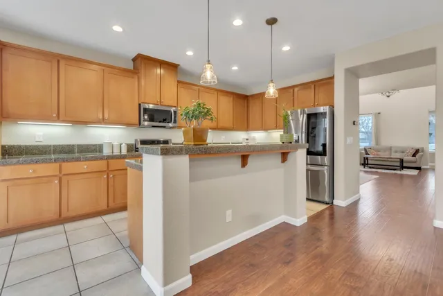 a kitchen with a sink a refrigerator and wooden floor
