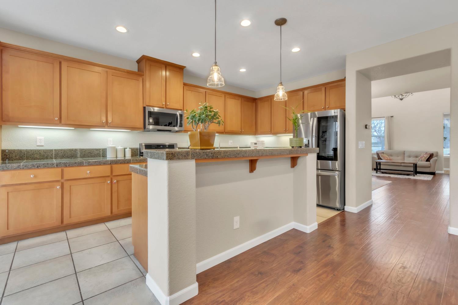 2993 Essie Place Modesto, CA 95355 - Photo 10 of 44 a kitchen with a sink a refrigerator and wooden floor