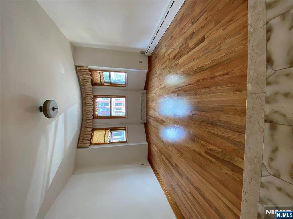 133 Oak Street, Unit 1 Weehawken, NJ 07086 - Photo 6 of 9 an empty room with wooden floor and windows