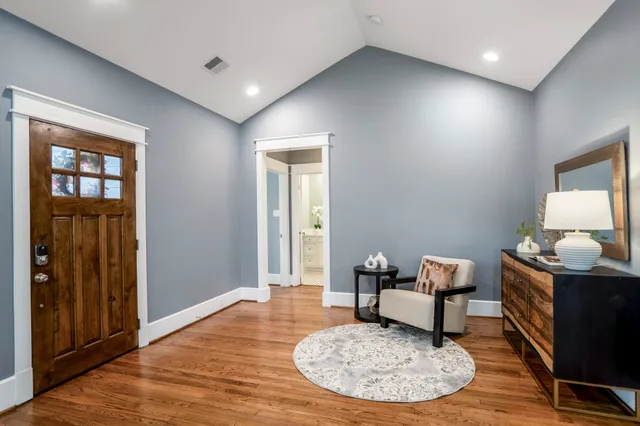 a living room with couch chairs and a wooden floor