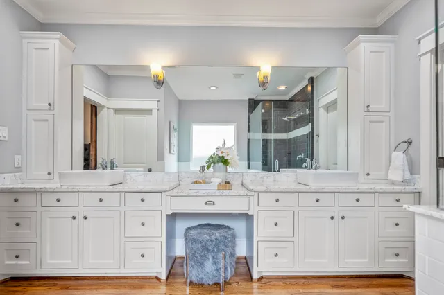 a bathroom with white cabinets and sink