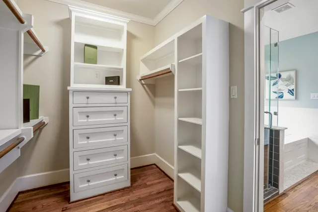 a view of walk in closet with wooden floor