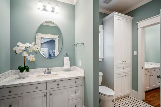 a bathroom with a granite countertop toilet a sink and a mirror