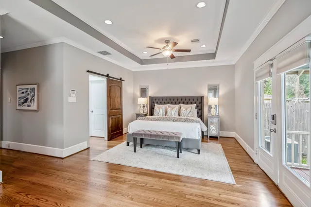 a bedroom with a bed chandelier and a window