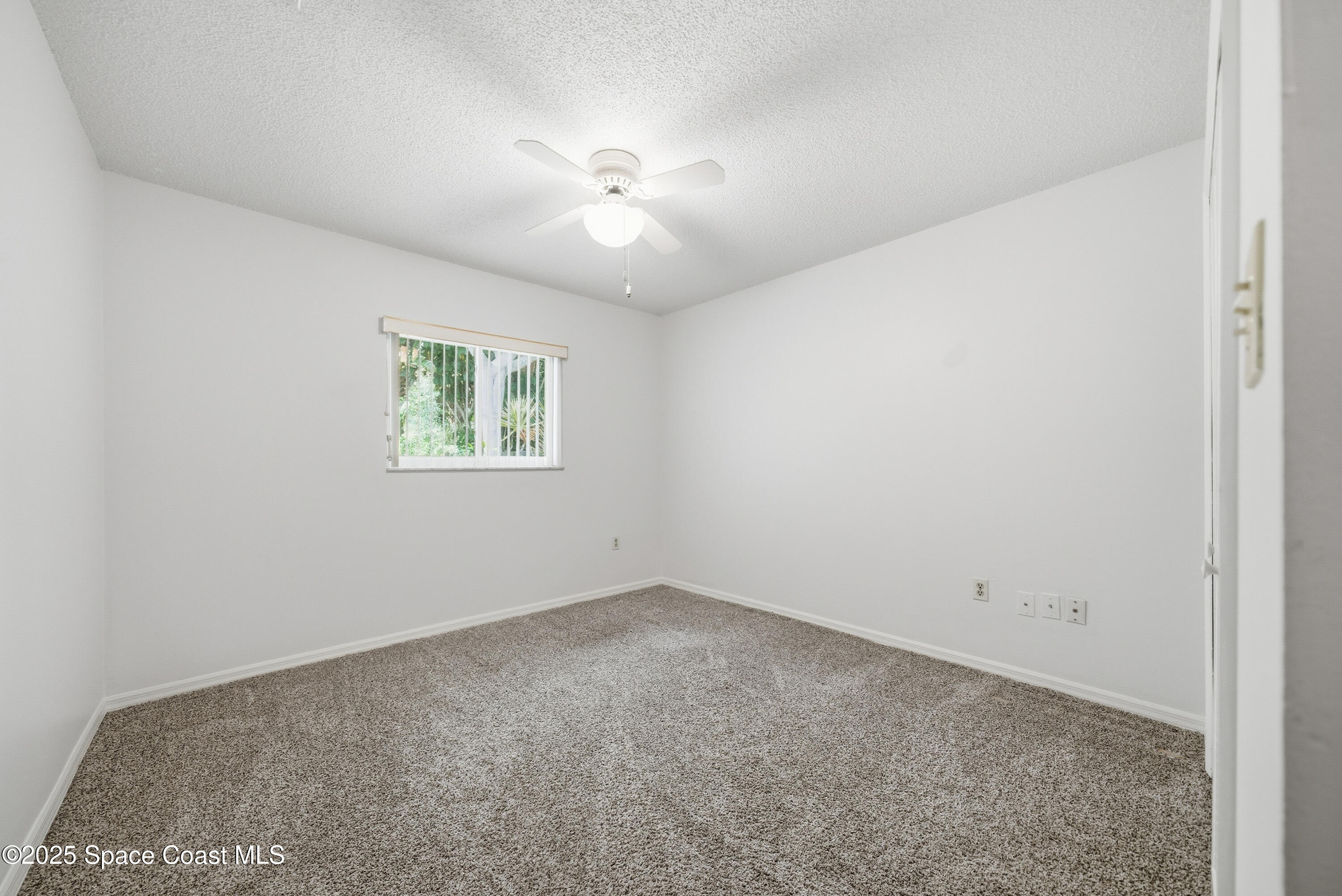 2108 Rosewood Drive Melbourne Beach, FL 32951 - Photo 17 of 39 an empty room with windows and fan