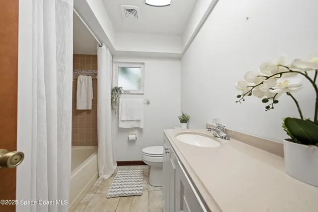 an empty room with windows and ceiling fan