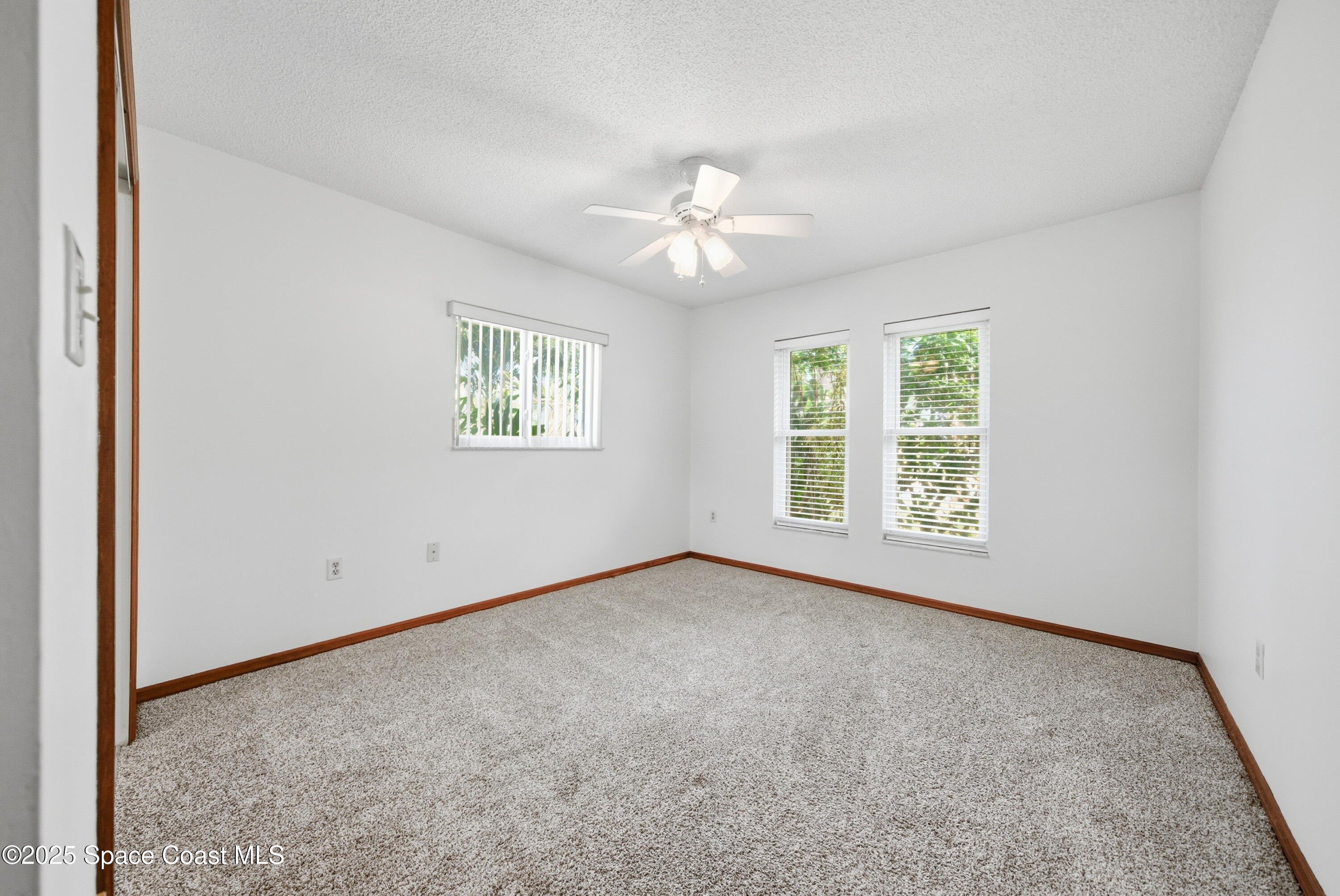 2108 Rosewood Drive Melbourne Beach, FL 32951 - Photo 20 of 39 an empty room with windows and ceiling fan