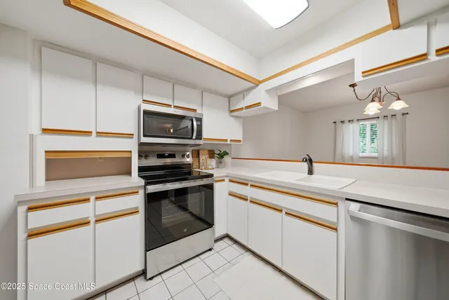 a kitchen with granite countertop white cabinets and appliances