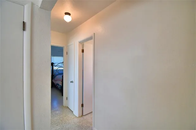 a view of a hallway with closet and a bathroom