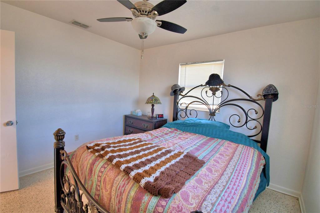 105 Maxcy Lane Frostproof, FL 33843 - Photo 22 of 49 a bedroom with a bed and a chandelier