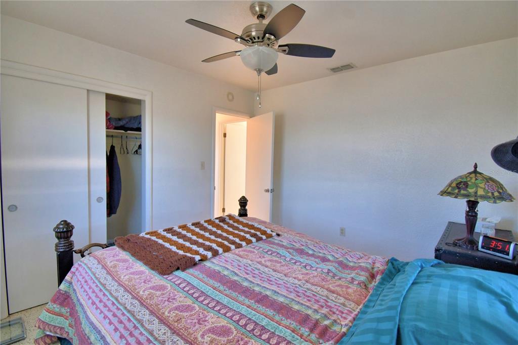 105 Maxcy Lane Frostproof, FL 33843 - Photo 23 of 49 a bedroom with a bed and a chandelier