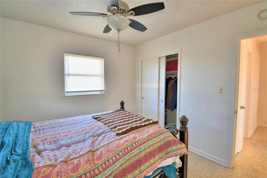 105 Maxcy Lane Frostproof, FL 33843 - Photo 24 of 49 a bedroom with a bed and a chandelier