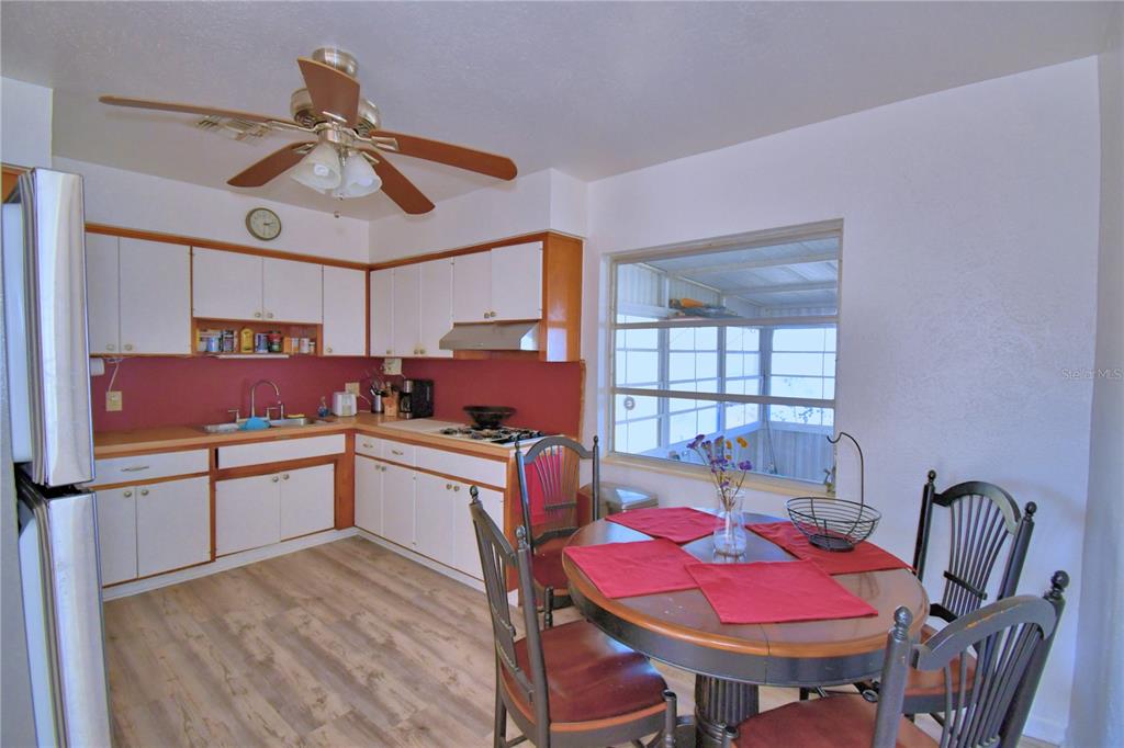 105 Maxcy Lane Frostproof, FL 33843 - Photo 7 of 49 a kitchen with a dining table chairs and white cabinets