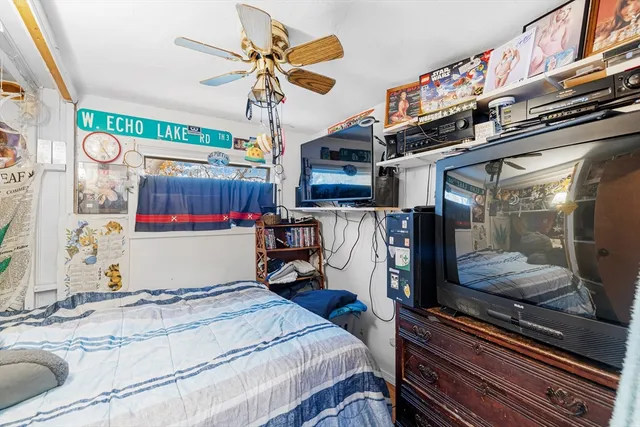 a bedroom with a bed and a mirror on the wall