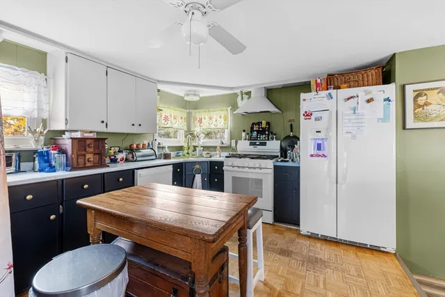 a kitchen with a table chairs refrigerator and cabinets