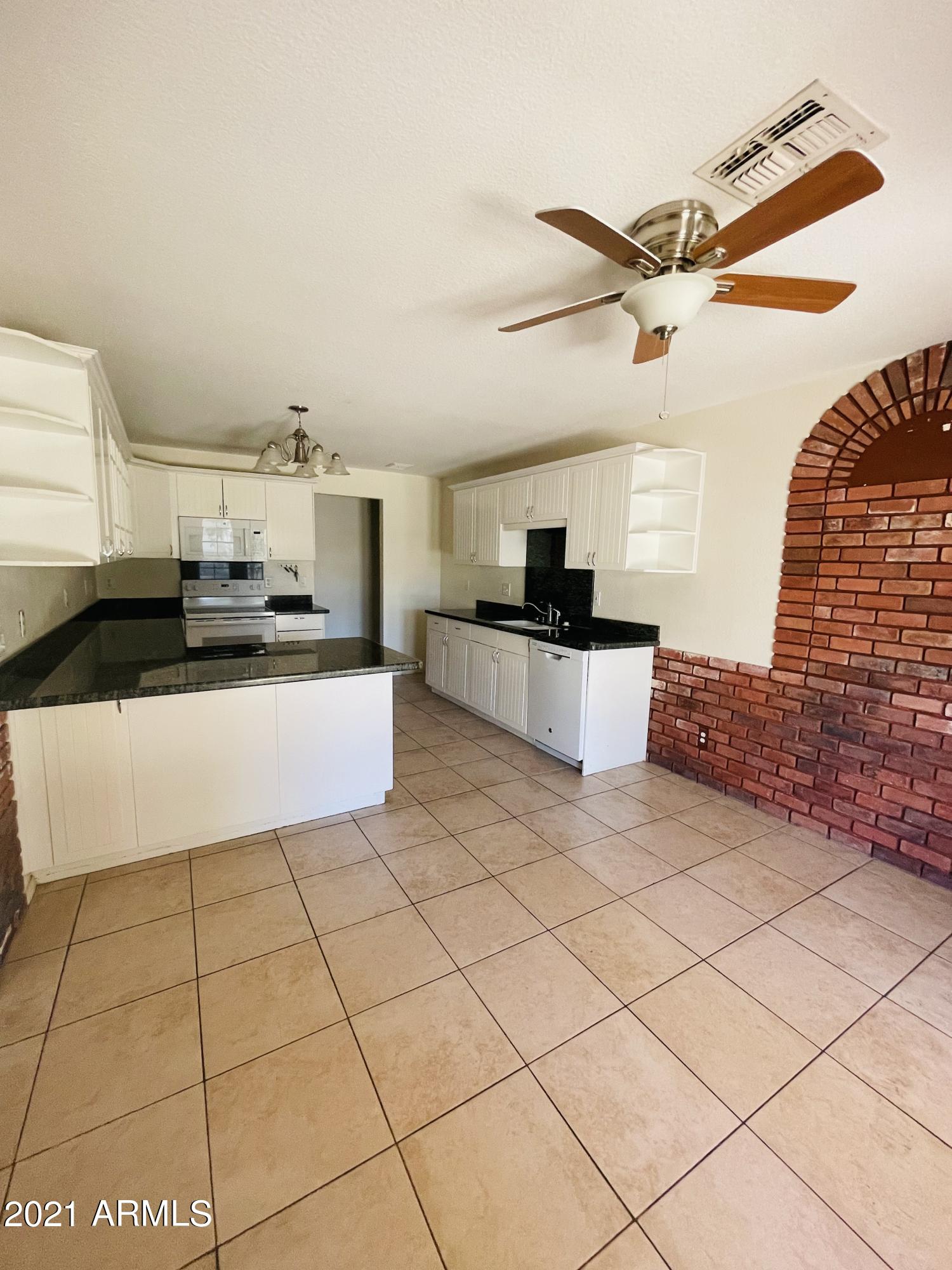10642 East Arbor Avenue Mesa, AZ 85120 - Photo 4 of 12 a kitchen with stainless steel appliances a refrigerator sink and cabinets