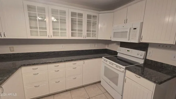 a kitchen with granite countertop white cabinets and sink
