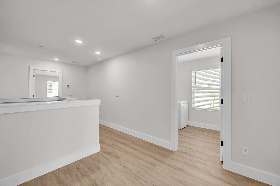 7600 Strong Bow Court Austin, TX 78744 - Photo 11 of 26 Corridor featuring healthy amount of natural light, light wood-type flooring, and recessed lighting
