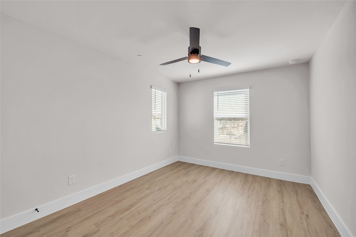 7600 Strong Bow Court Austin, TX 78744 - Photo 17 of 26 Spare room featuring light wood-type flooring and ceiling fan