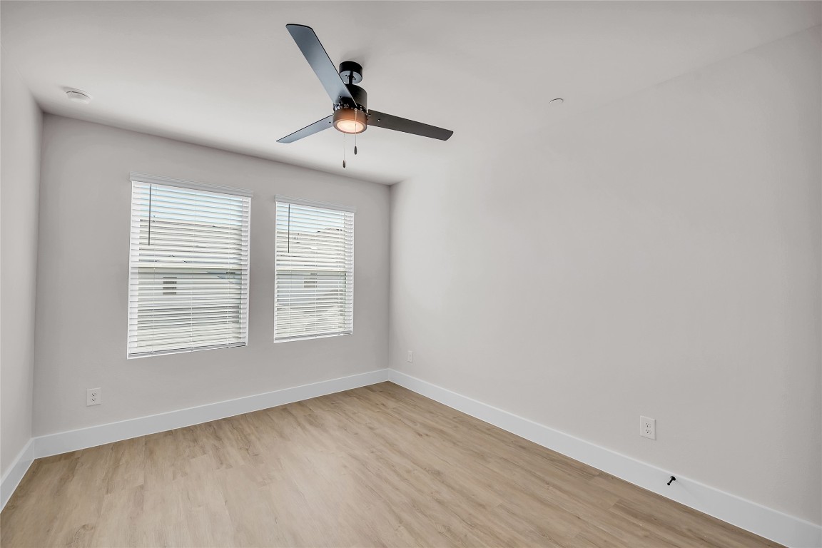 7600 Strong Bow Court Austin, TX 78744 - Photo 19 of 26 Unfurnished room featuring light wood finished floors and a ceiling fan