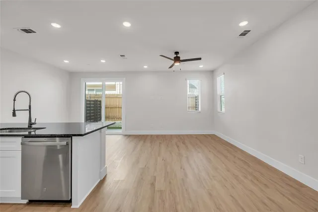 a view of kitchen with kitchen island wooden floor center island and stainless steel appliances
